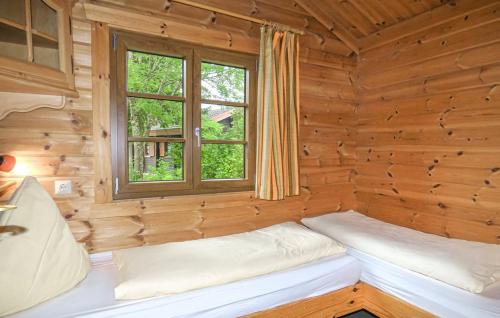 Cette chambre avec 2 lits se trouve dans une cabane en rondins dotée d'une fenêtre. dans l'établissement Ferienhaus Neckar 45, à Hayingen