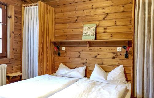 two beds in a room with wooden walls at Ferienhaus Neckar 70 in Hayingen