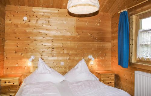 a bed in a room with a wooden wall at Ferienhaus Donau 18 in Hayingen