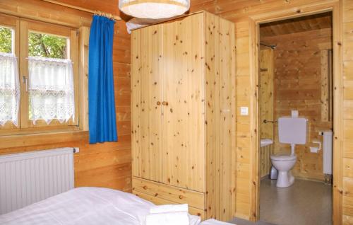 Cette chambre en bois comprend un lit et des toilettes. dans l'établissement Ferienhaus Donau 18, à Hayingen