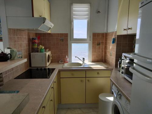 une petite cuisine avec un évier et une fenêtre dans l'établissement Appartement moderne avec vue mer pour 4 personnes à Saint-Jean-de-Monts - FR-1-323-335, à Saint-Jean-de-Monts
