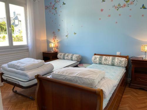 um quarto com 2 camas e uma parede azul em Maison Belz, 3 pièces, 4 personnes - FR-1-397-67 em Belz