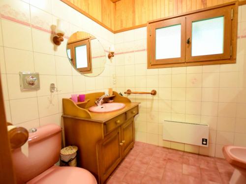 W łazience znajduje się umywalka, toaleta i lustro. w obiekcie Chalet Bernex, 5 pièces, 10 personnes - FR-1-498-94 w mieście Bernex