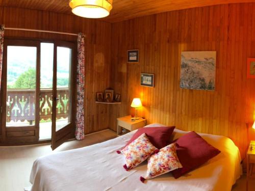 een slaapkamer met een bed met kussens en een raam bij Chalet Bernex, 5 pièces, 10 personnes - FR-1-498-94 in Bernex