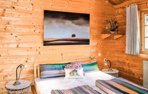 a bedroom with a wooden wall with a bed and two lamps at Ferienhaus Tauber 84 in Hayingen