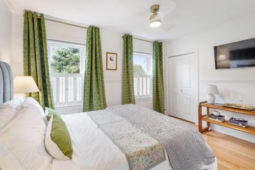 a bedroom with a bed and two windows at The Front Porch Vacation Rentals in Bristol