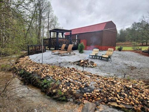 a group of chairs and a fire pit next to a barn at Lazy Bear Retreat by the Creek in Pickens
