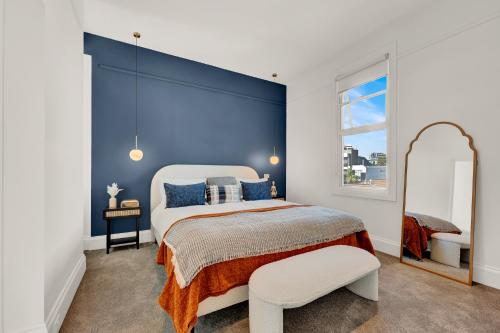 - une chambre avec un grand lit et un miroir dans l'établissement Paris End of St Kilda Apartment, à Melbourne