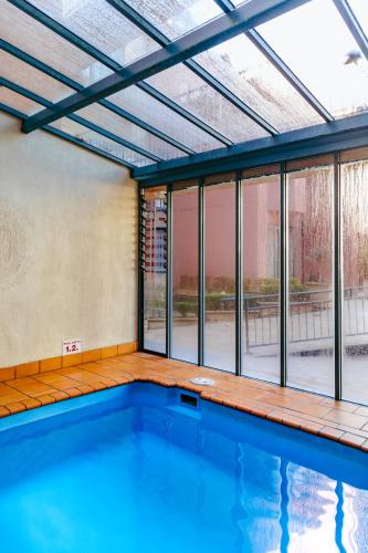 an indoor swimming pool with a large window at Paris End of St Kilda Apartment in Melbourne