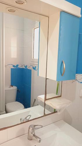 uma casa de banho com um lavatório, um espelho e um WC. em Kalthoum em Chott Meriem