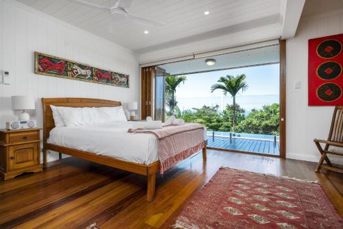 a bedroom with a bed and a large window at Stu’s Lookout - 4 Bedroom Use - Stunning Views in Mission Beach