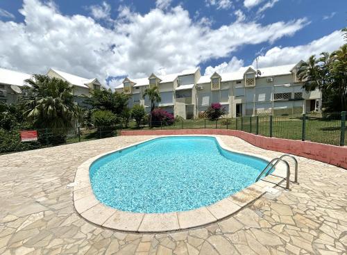 een zwembad voor een gebouw bij Le refuge de Chrystel : Plage accessible à pied in Le Gosier