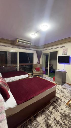 a large bedroom with a large bed and a television at Nile Star Suites & Apartments in Cairo