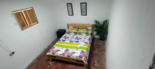 1 dormitorio con 1 cama en una pared blanca en Encanto Natural en Villagarzón