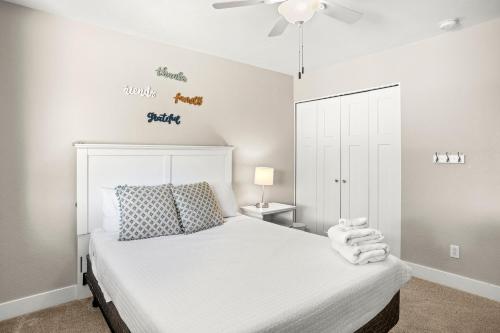a bedroom with a white bed and a ceiling fan at Tempe Getaway - Pool - Putting Green in Tempe