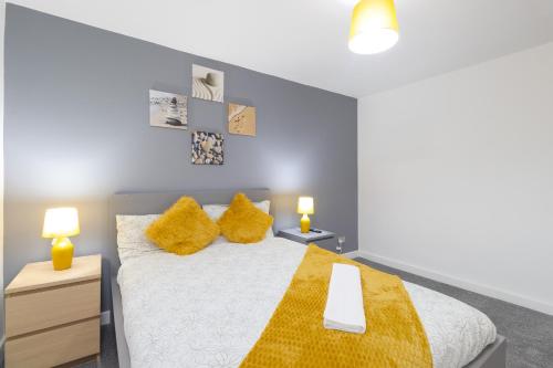 um quarto com uma cama grande e almofadas amarelas em Modern Comfort, 4-BR, Sleeps 8, Ensuite em Northampton