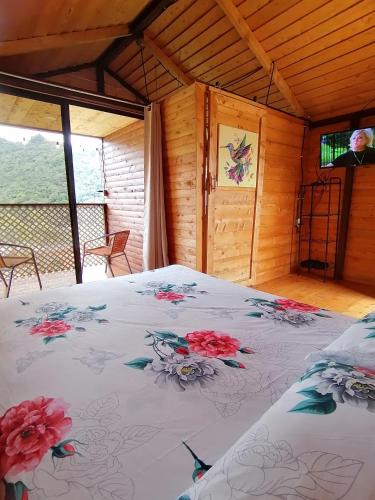 ein Schlafzimmer mit einem Bett mit Blumen darauf in der Unterkunft Mario's Lodge Providencia in Copey