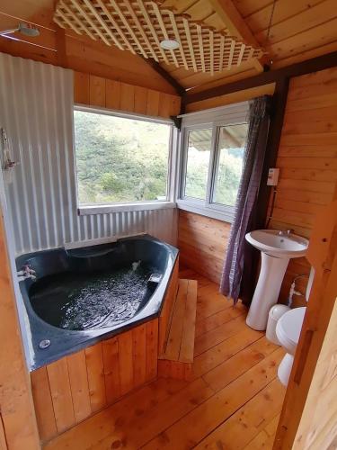 ein Badezimmer mit einer großen Badewanne und einem Waschbecken in der Unterkunft Mario's Lodge Providencia in Copey