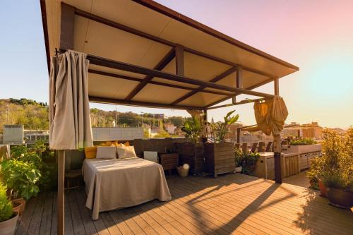 a bed under an umbrella on a deck at Apartment with Terrace Views of BCN in Barcelona