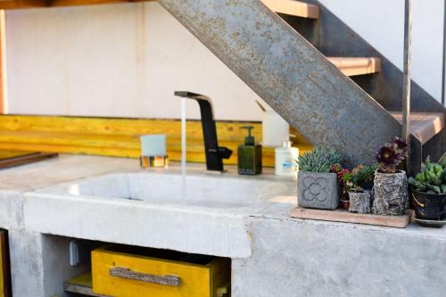 a kitchen sink with a faucet and some plants at Apartment with Terrace Views of BCN in Barcelona