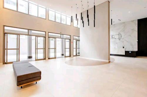 um quarto grande com um banco no meio em Flat de Luxo em Pinheiros Faria Lima em São Paulo