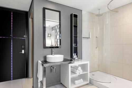uma casa de banho com um lavatório e um espelho em Protea Hotel Fire & Ice! by Marriott Johannesburg Melrose Arch em Joanesburgo