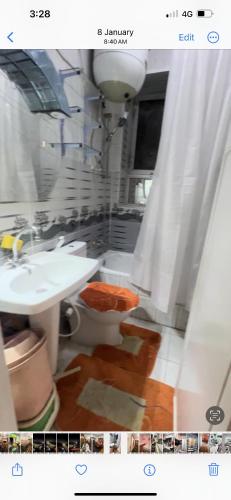 La salle de bains est pourvue d'un lavabo blanc et de toilettes. dans l'établissement ابراج عثمان اغاخان كورنيش النيل, au Caire