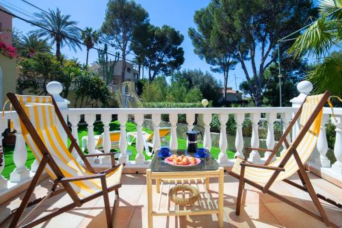 - deux chaises et une table sur une terrasse couverte avec une clôture blanche dans l'établissement Casa Choco, à Altea