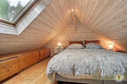 ein Bett in einem Zimmer mit Holzdecke in der Unterkunft Au bord du ruisseau in Saint-Quay-Perros