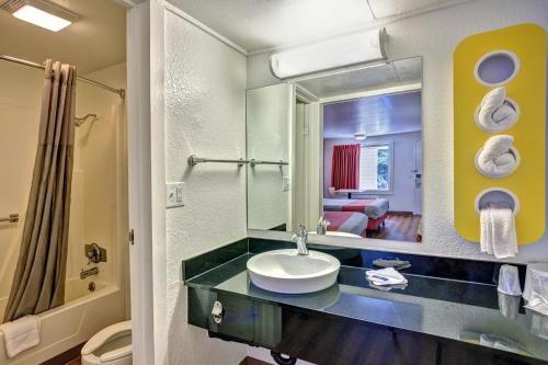 a bathroom with a sink and a mirror at Travelodge by Wyndham Fayetteville in Fayetteville