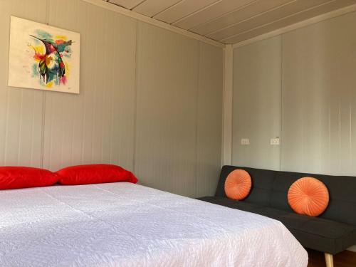 1 dormitorio con 1 cama y 1 sofá en Mario's Lodge Providencia, en Copey