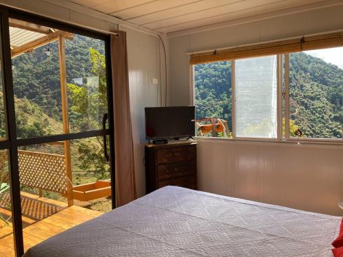 a bedroom with a bed and a window with a television at Mario's Lodge Providencia in El Copey