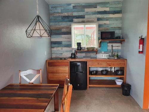 a kitchen with a black refrigerator and a table at Rachel Land in Caye Caulker