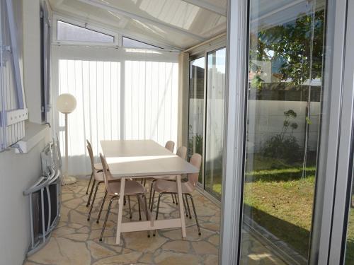 une salle à manger avec une table et des chaises blanches dans l'établissement Maison charmante, 5 pers, wifi, quartier calme, jardin clos, près plage et commerces - FR-1-323-537, à Saint-Jean-de-Monts
