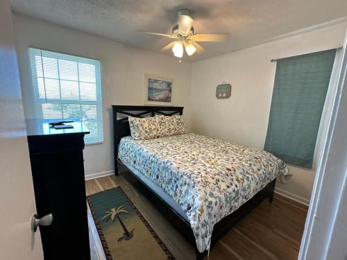 a bedroom with a bed and a ceiling fan at OceanView Oasis - Relax with Hot Tub, Breakfast, Fire Pit & Putting Green! in Panama City Beach
