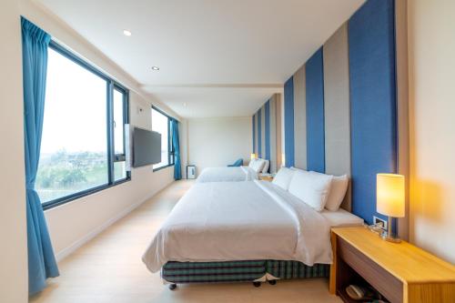 a bedroom with a large bed and a large window at Sunshine Palm B&B in Magong
