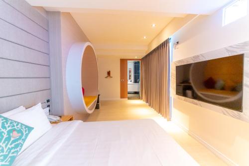 a bedroom with a white bed and a mirror at Sunshine Palm B&B in Magong