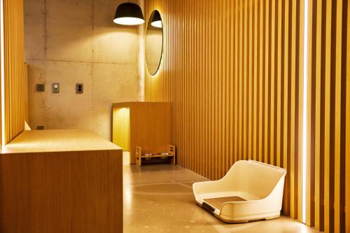 a bathroom with a white chair and a desk at Playce Camp Jeju in Seogwipo
