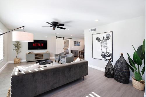 a living room with a couch and a tv at Pegasus - Modern Tempe Getaway with Pool & Game Room in Tempe