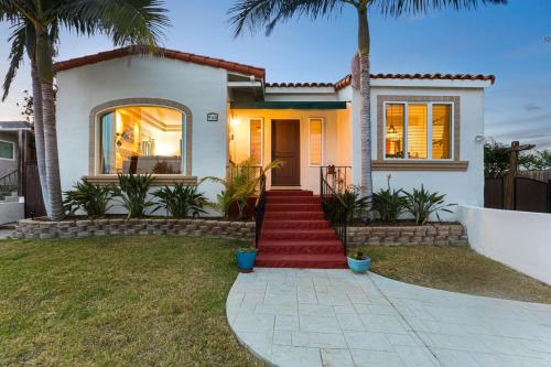 a house with palm trees in front of it at La Playa - Charming Bayside Bungalow in San Diego