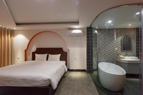 a bedroom with a bed and a bath tub at Sapa Hai Yen Hotel and Apartment in Sa Pả