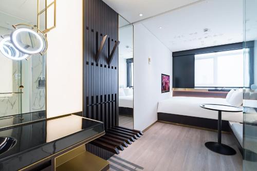 a bedroom with a bed and a table in a room at CitiGO Hotel Hongqiao Shanghai in Shanghai
