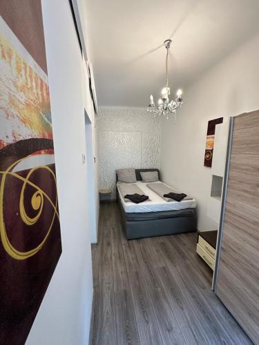 a bedroom with a bed and a chandelier at City Apartment Hauptbahnhof in Graz