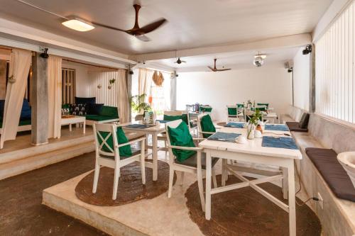 a dining room with tables and green chairs at B4 BOUTIQUE in Paje