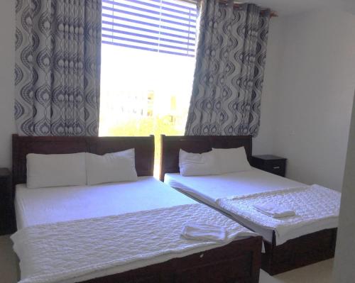 - 2 lits jumeaux dans une chambre avec fenêtre dans l'établissement Nam Dương 2 Hotel, à Phan Rang