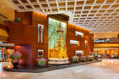 a lobby with a statue in the middle of a building at Royal Orchid Sheraton Hotel and Towers in Bangkok