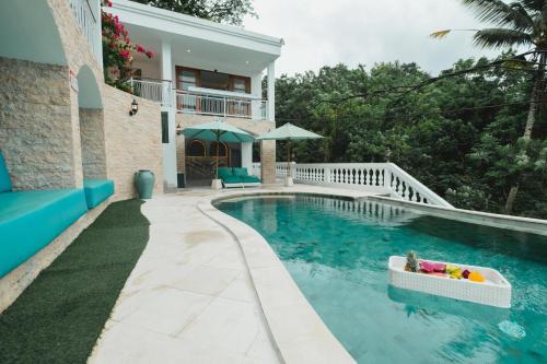 a swimming pool in front of a house at Royal Maharani Payogan in Ubud