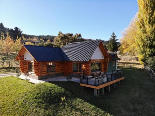 uma cabana de madeira com um telhado de metal num quintal em Villa Soñada - Encantadora Casa para 6 Personas em Esquel