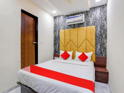 a bedroom with a large bed with red pillows at Hotel King View in Ahmedabad