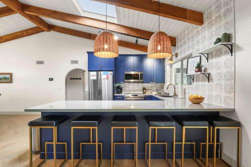 a kitchen with blue cabinets and a large island with stools at Olive Tree Retreat - Heated Pool, Patio & Privacy in Scottsdale